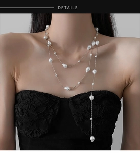 Detail of layered baroque pearl necklace with silver chain on model for elegant styling