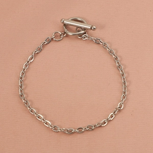Detail showing the silver OT buckle clasp and minimalist link chain design of the necklace