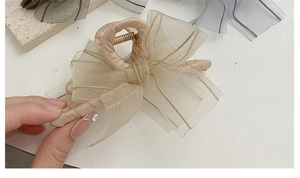 Detail of elegant champagne mesh bow hair claw clip with a strong metal spring mechanism