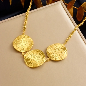 Golden irregular hammered texture geometric spiral pendant necklace on a beige display surface