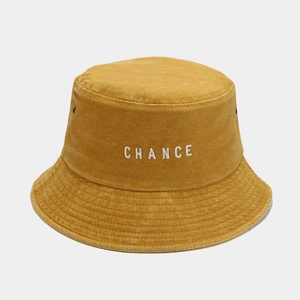 Close-up of CHANCE white embroidery on yellow washed cotton bucket hat texture