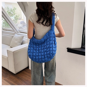 Detailed view of blue cloud puff tote bag with quilted texture and soft padded shoulder strap