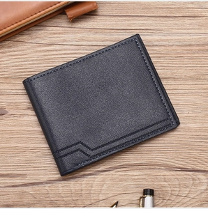 Detail of navy blue leather wallet with lychee texture and fine stitching on wood