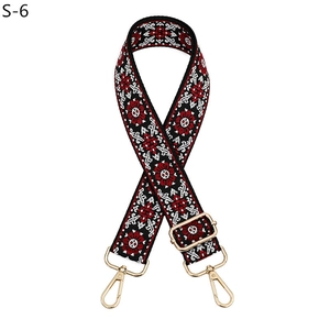 Close-up of ethnic geometric pattern bag strap with high-gloss gold metal swivel hooks