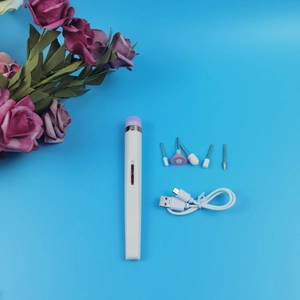 Dettaglio set manicure elettrico 5-in-1 con punte e cavo USB su superficie blu