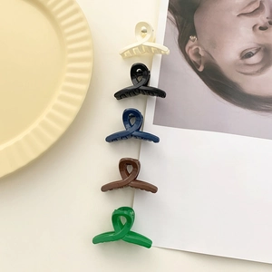 Set of five matte minimalist hair claws in various colors displayed on a plate