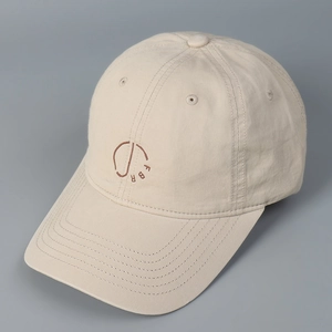 Detail view of the beige washed cotton baseball cap featuring high-quality FBR embroidery
