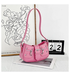 Close-up of pink motorcycle-style bag with silver studs and Y2K aesthetic metal buckles