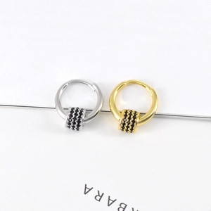 Macro view of rotating round drop earrings with micro-pave black zircons on a metal bar