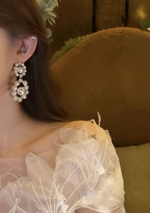 Detail of vintage French style pearl drop earrings with zircon on elegant female model