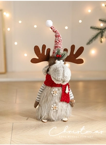 Close-up of plush Christmas reindeer with red knit hat and snowflake button detail