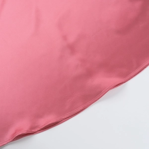 Close-up detail of pink satin dress showing fine rolled hem stitching and glossy fabric