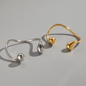 Macro shot of minimalist gold and silver open bangles with sleek geometric lines