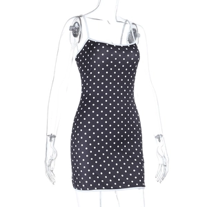Détail de la robe moulante noire à pois avec fines bretelles sur un mannequin transparent