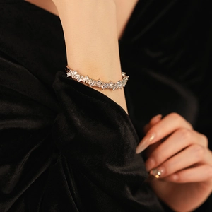 Détail macro d'un bracelet jonc argenté avec zircons sertis sur fond de velours noir