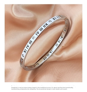 Macro shot of silver titanium steel bangle with Roman numerals and inlaid zircon crystals