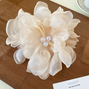 Detailed macro view of cream lace petals and triple faux pearl center on large hair claw clip