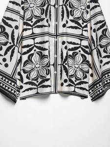Gros plan détaillé sur l'imprimé floral exotique et la texture de la chemise à manches longues