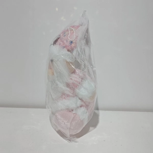 Close-up of pink sequined Santa plush doll with white beard in clear storage packaging