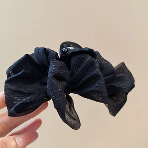 Close-up of black mesh hair claw clip with silver shimmer stripes on tulle fabric