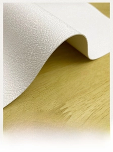 Detail of thickened white leather placemat showing soft texture and flexibility