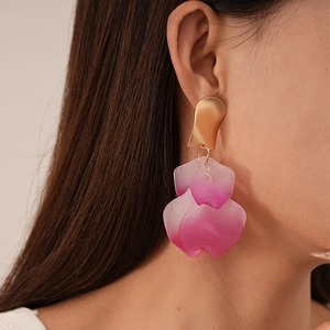 Close-up of petal earrings with gold metallic top and pink gradient acrylic petals