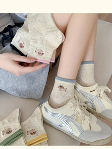 Detail of dog embroidery on knit socks with colorful speckled yarn and contrast trim