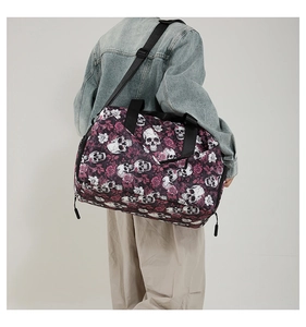 Detail of gothic skeleton and rose print on a large capacity oxford travel duffel bag