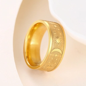 Detailed close-up of matte gold ring featuring embossed sun, moon, and star patterns