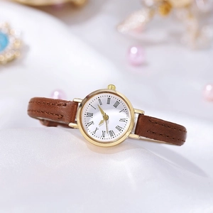 Elegant vintage quartz watch with a golden case, Roman numerals, and brown leather strap