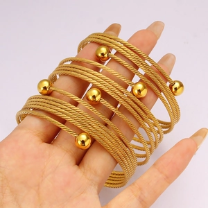 Bracciale rigido multifilo in acciaio dorato con charm a sfera stile minimalista