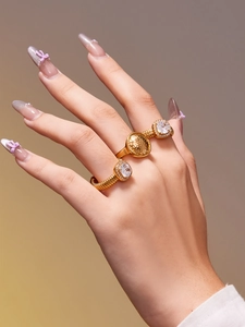 Détail de trois bagues en acier inoxydable plaqué or 18 carats avec zircon et textures