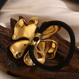 Macro shot of 18K gold plated floral charm with sparkling diamonds on a black elastic hair tie