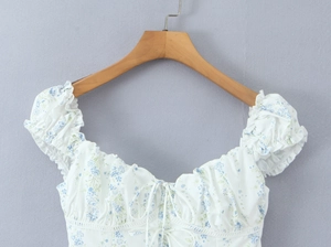 Detail of white floral blouse showing puff sleeves and drawstring sweetheart neckline