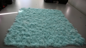Detailed top view of light blue synthetic long-pile artificial moss lawn carpet