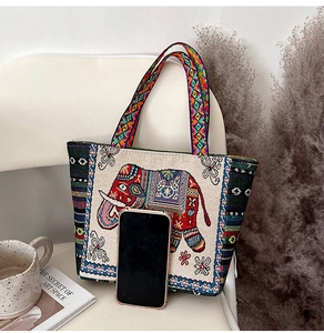 Ethnic style canvas tote bag featuring elephant embroidery and geometric patterned straps