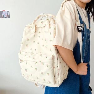 Creamy floral canvas backpack for students featuring a pink flower pattern and front pocket