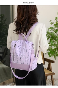 Rückansicht eines Models mit dem floralen lavendelfarbenen Oxford-Rucksack mit Lederdetails