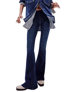 Detailed close-up showing the dark blue denim texture and stitching of flared jeans