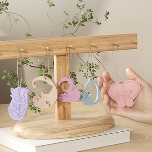 Pastel cat resin molds and keychains in cute shapes displayed on a wooden stand