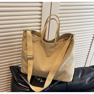 Detail of khaki canvas tote bag with adjustable shoulder strap and sturdy handles