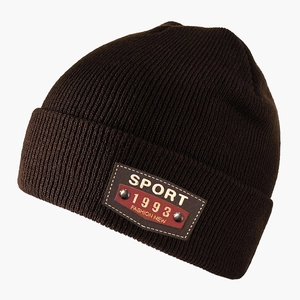 Detailed close-up of dark brown knit beanie featuring leather patch and metal rivets