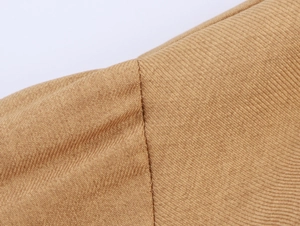 Macro shot of khaki corduroy fabric texture and stitching details on a women's shirt
