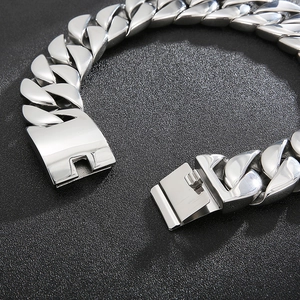 Chunky silver hip hop Cuban link chain bracelet with a square clasp on black surface