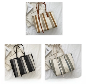 Detailed view of striped canvas tote bags in brown, black, and white with leather straps
