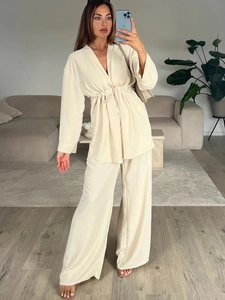 Women's two-piece beige loungewear set with V-neck drawstring top and wide-leg silk pants