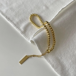 Detailed macro view of S925 sterling silver gold beaded bracelet with adjustable chain