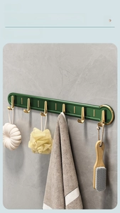 Detail view of emerald green and gold luxury wall hooks with bath accessories
