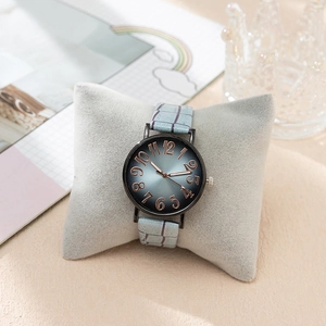 Detail of elegant women's quartz watch with blue sunray dial and embossed gold numerals
