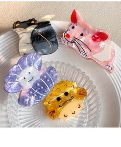 Detail view of acetate hair claws featuring cat, mouse, shell and hedgehog designs